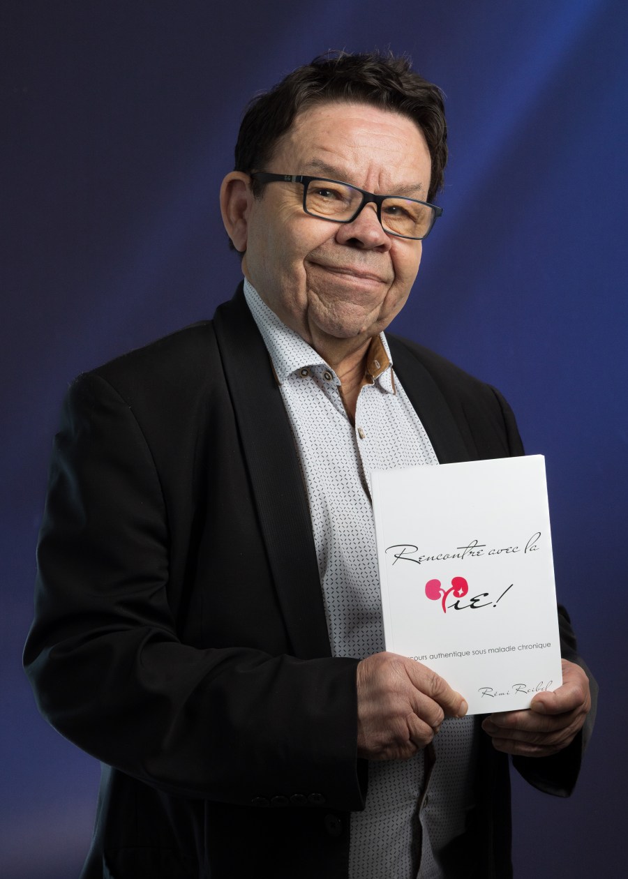 Rémi Reibel tenant son livre « Rencontre avec la Vie »